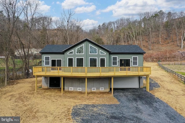 back of house featuring a deck and a garage