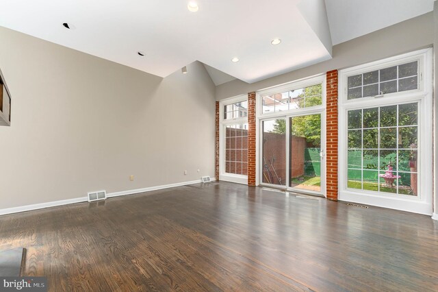 unfurnished living room with vaulted ceiling, wood-type flooring, and a wealth of natural light