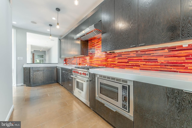 kitchen featuring pendant lighting, appliances with stainless steel finishes, light tile patterned flooring, tasteful backsplash, and wall chimney range hood