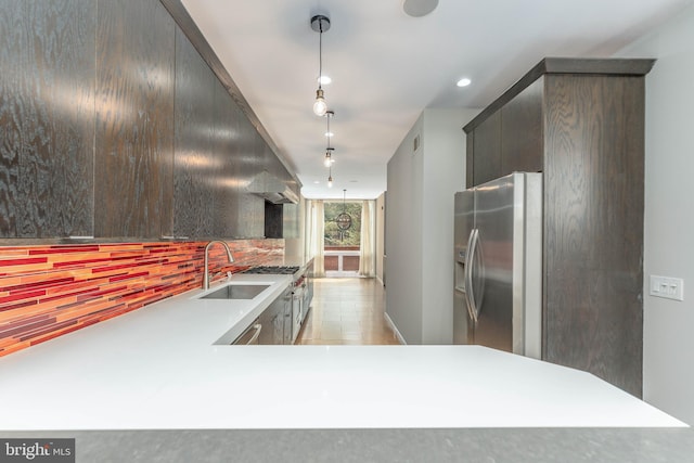 kitchen featuring hanging light fixtures, sink, stainless steel fridge, light tile patterned floors, and decorative backsplash