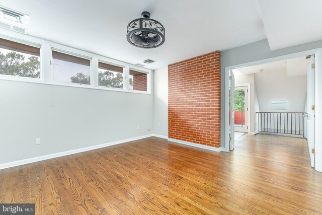 spare room featuring a wealth of natural light and hardwood / wood-style flooring