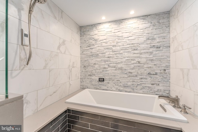 bathroom featuring tiled shower / bath combo and tile walls