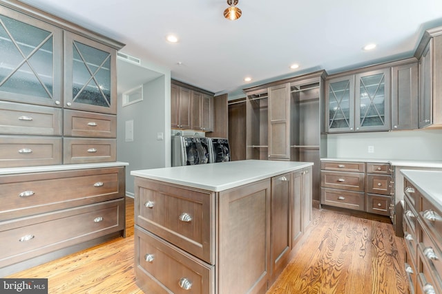 walk in closet featuring independent washer and dryer and light hardwood / wood-style floors