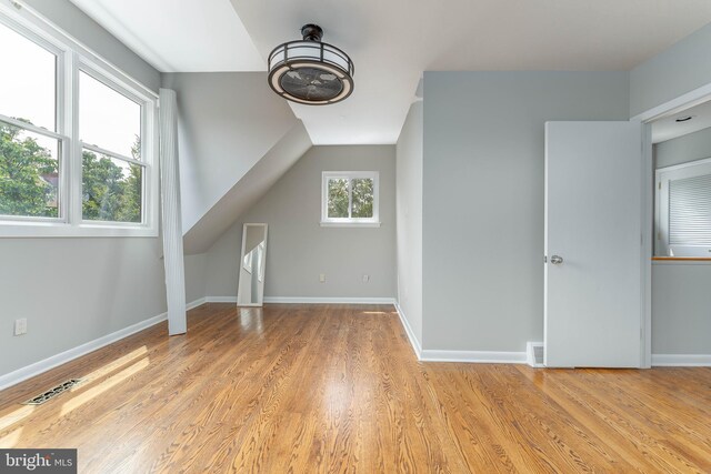 bonus room with lofted ceiling and light hardwood / wood-style floors