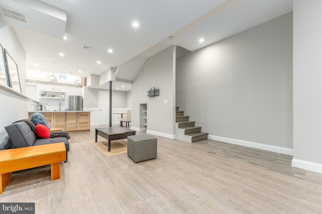 living room featuring vaulted ceiling and light hardwood / wood-style flooring