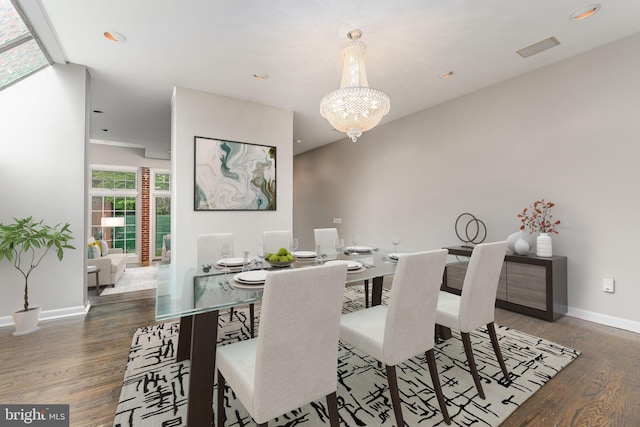 dining area with dark wood-type flooring and a chandelier