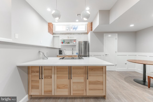 kitchen featuring pendant lighting, light brown cabinetry, stainless steel fridge, light hardwood / wood-style flooring, and kitchen peninsula