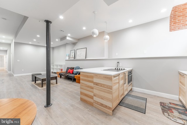 kitchen featuring light wood-type flooring, light brown cabinets, stainless steel oven, hanging light fixtures, and brick wall