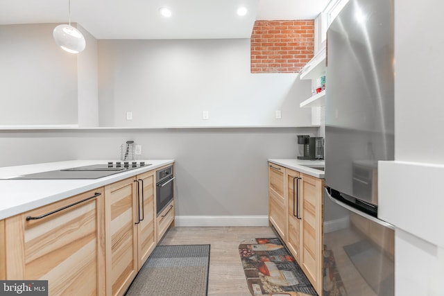 kitchen featuring light brown cabinets, oven, pendant lighting, black electric stovetop, and light hardwood / wood-style floors