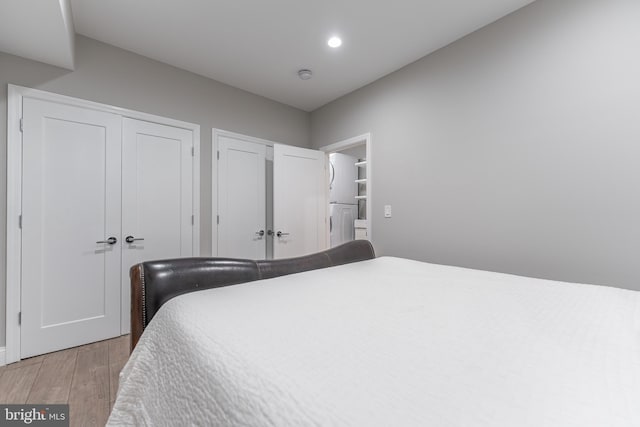 bedroom featuring light hardwood / wood-style floors and two closets