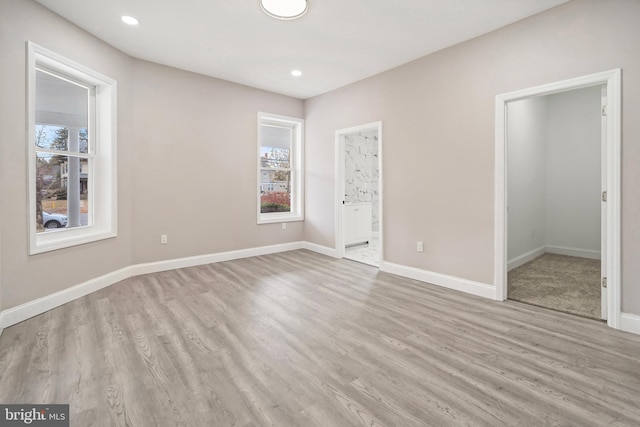 spare room featuring recessed lighting, baseboards, and wood finished floors