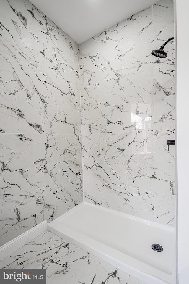 full bath featuring marble finish floor and walk in shower