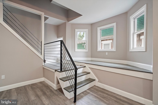 stairway with baseboards and wood finished floors