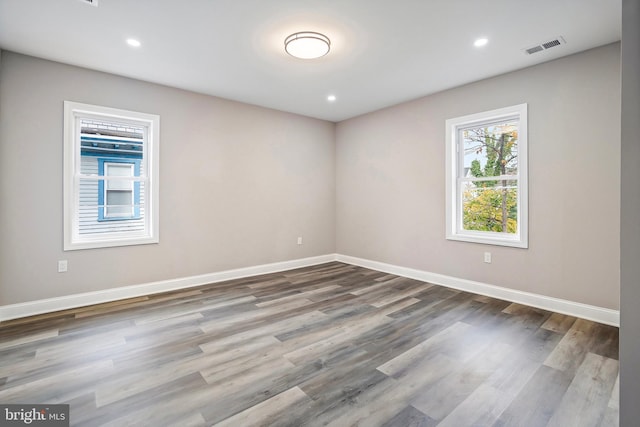 spare room with recessed lighting, visible vents, baseboards, and wood finished floors