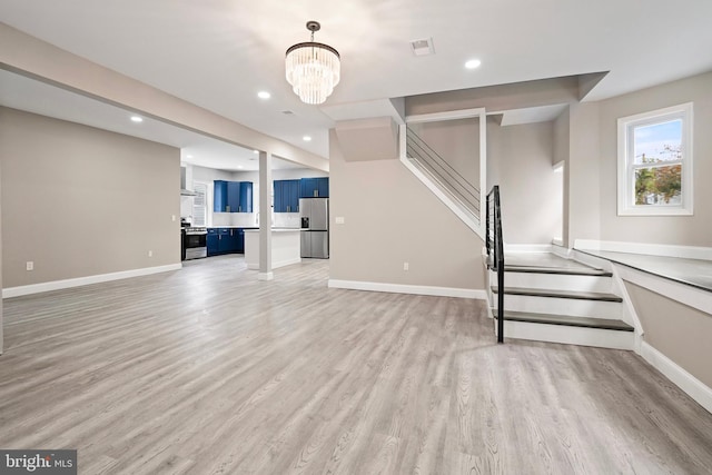 unfurnished living room with stairway, visible vents, baseboards, light wood-style flooring, and recessed lighting