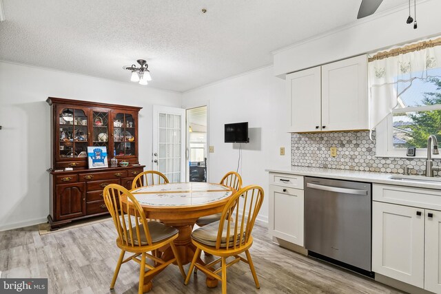 kitchen with appliances with stainless steel finishes, white cabinets, light wood-type flooring, and ceiling fan