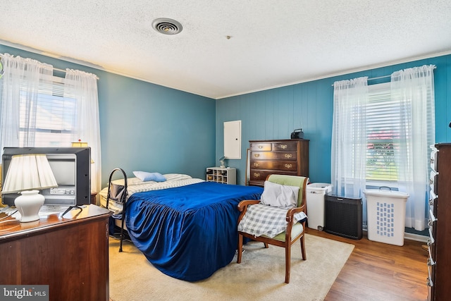 bedroom with a textured ceiling and hardwood / wood-style floors