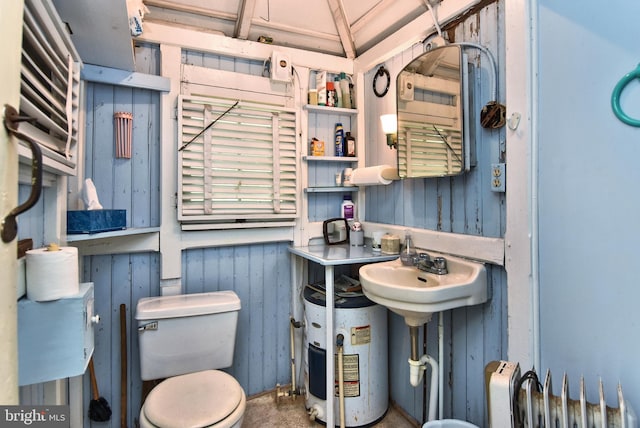 bathroom featuring sink, water heater, and toilet