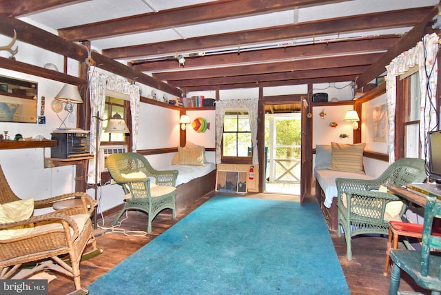 sitting room with dark wood-type flooring and beam ceiling