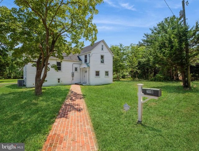 view of front of house with a front lawn and central air condition unit