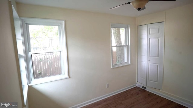 unfurnished bedroom with dark hardwood / wood-style floors, ceiling fan, and a closet