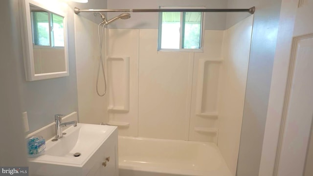 bathroom with a healthy amount of sunlight, shower / bath combination, and vanity