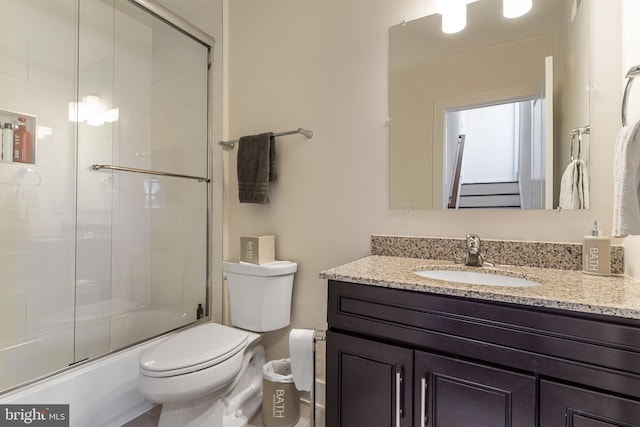 full bathroom with toilet, enclosed tub / shower combo, and vanity