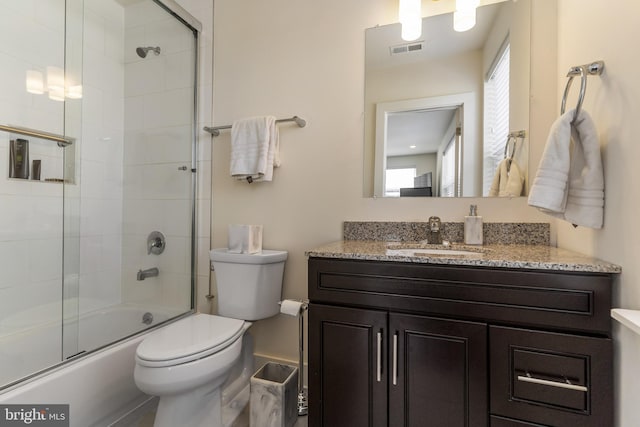 full bathroom featuring combined bath / shower with glass door, vanity, and toilet