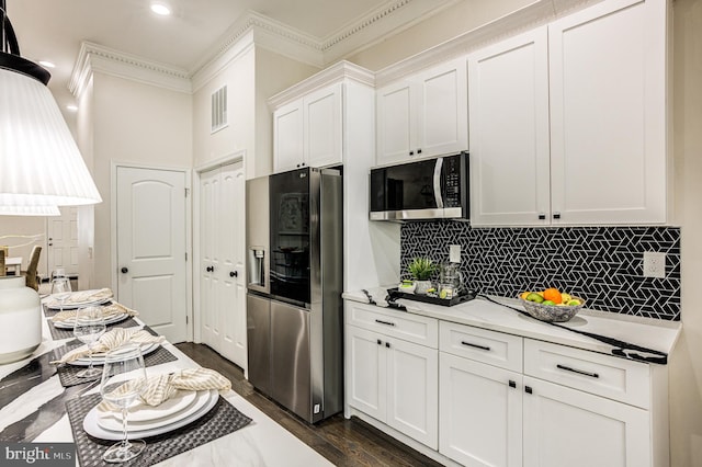 kitchen featuring backsplash, dark wood-type flooring, white cabinetry, stainless steel appliances, and crown molding