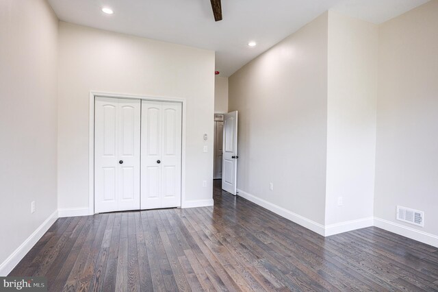 unfurnished bedroom with ceiling fan, a closet, and dark hardwood / wood-style floors