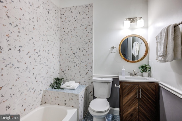 bathroom with vanity, a tub to relax in, and toilet