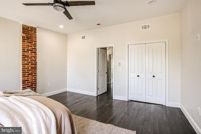 unfurnished bedroom with dark wood-type flooring, ceiling fan, and a closet