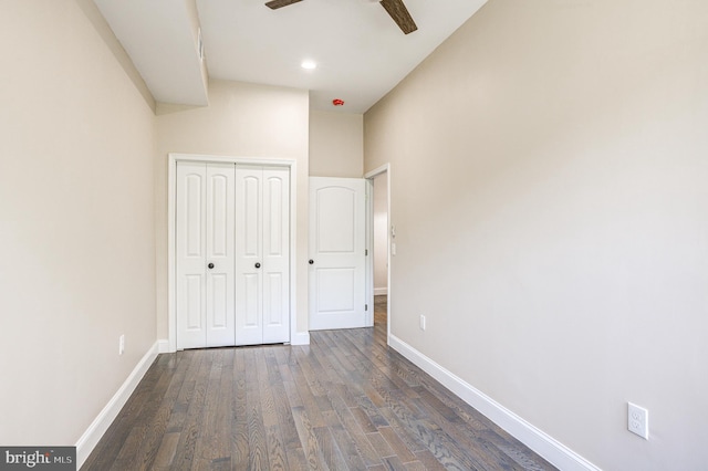 unfurnished bedroom featuring dark wood-type flooring, ceiling fan, and a closet