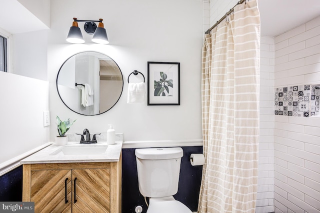 bathroom with curtained shower, vanity, and toilet