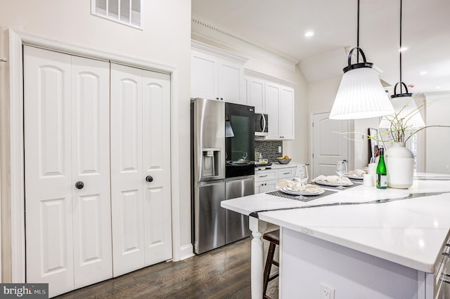 kitchen with dark wood-type flooring, white cabinetry, appliances with stainless steel finishes, decorative light fixtures, and crown molding