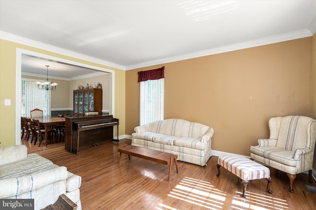 living room with crown molding, a notable chandelier, and wood-type flooring