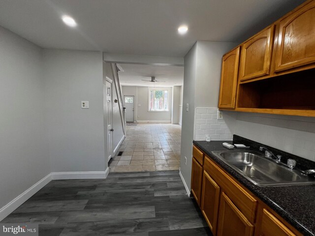 kitchen with ceiling fan, sink, dark hardwood / wood-style floors, and backsplash