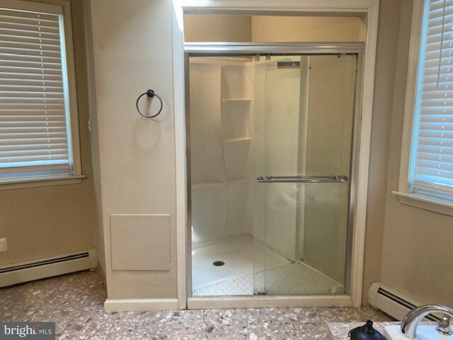 bathroom featuring a baseboard heating unit and walk in shower