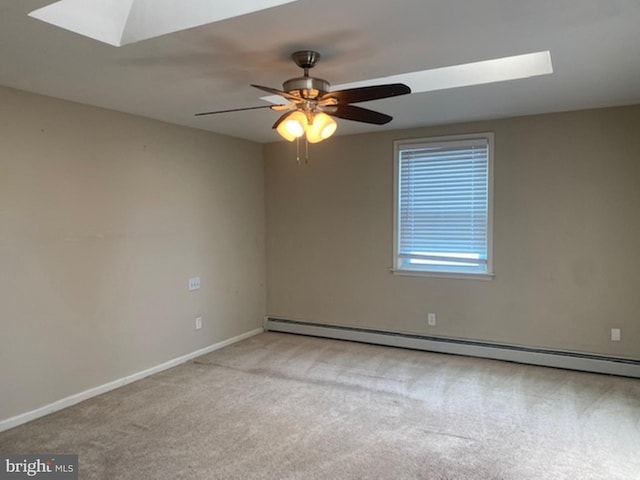 carpeted empty room featuring a baseboard heating unit, ceiling fan, and a skylight