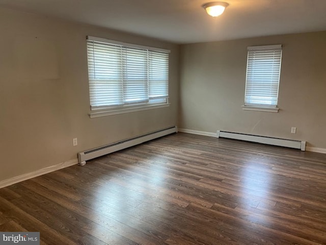 spare room with dark wood-type flooring and baseboard heating