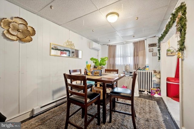 dining space with radiator, an AC wall unit, a baseboard radiator, and a paneled ceiling