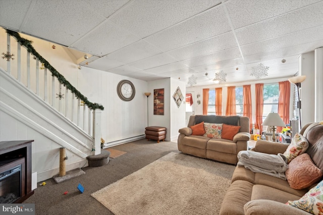 living room featuring a baseboard heating unit, a drop ceiling, and carpet