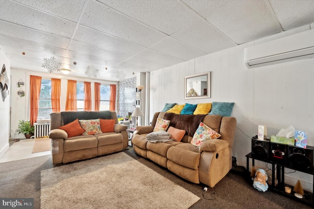 carpeted living room with a drop ceiling and a wall mounted air conditioner