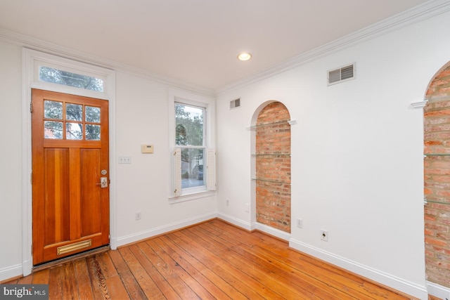 entrance foyer featuring crown molding and light wood-type flooring