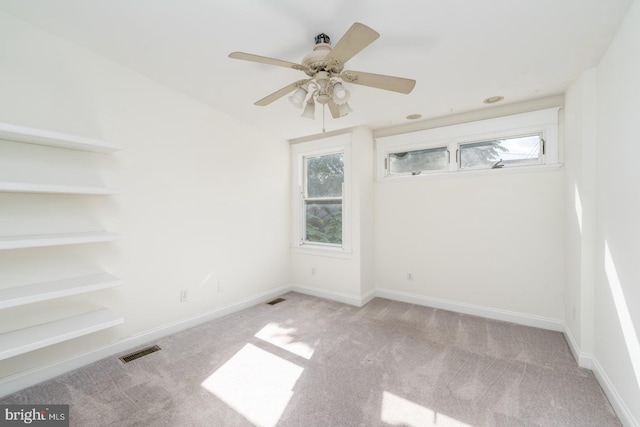 carpeted spare room with ceiling fan