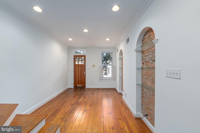 entrance foyer with light hardwood / wood-style floors and crown molding