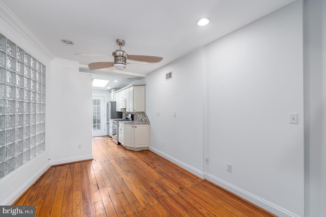 unfurnished room featuring ceiling fan, light hardwood / wood-style floors, and ornamental molding