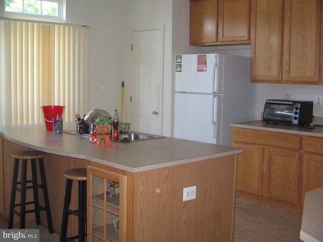 kitchen featuring a center island, white refrigerator, and light tile patterned floors