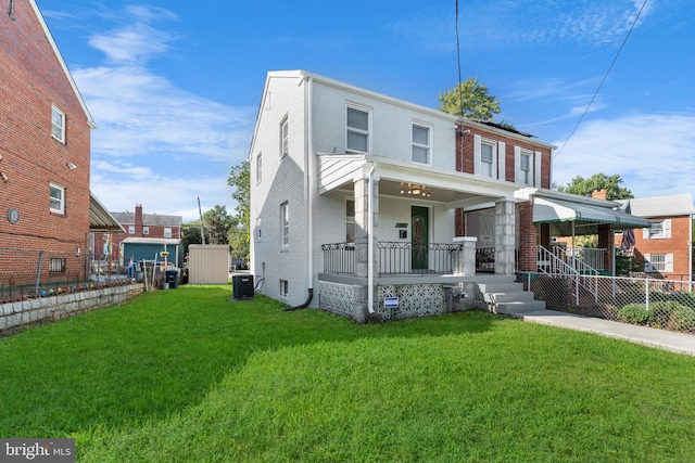 view of front facade with a front yard, central AC, and covered porch