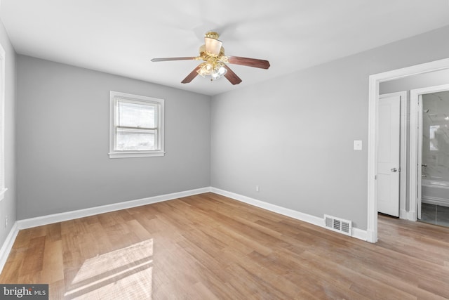 unfurnished room with wood finished floors, visible vents, baseboards, and ceiling fan